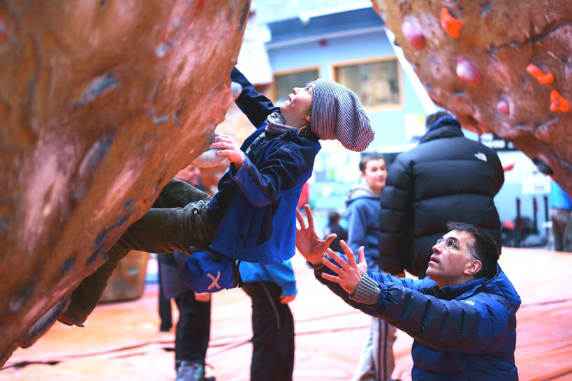 A young climber gets to grips with the wall with adult supervision