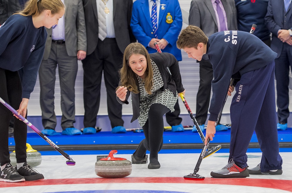 Minister for Public Health and Sport Aileen Campbell throws the first stone at the National Curling Academy with help from Stirling High pupils