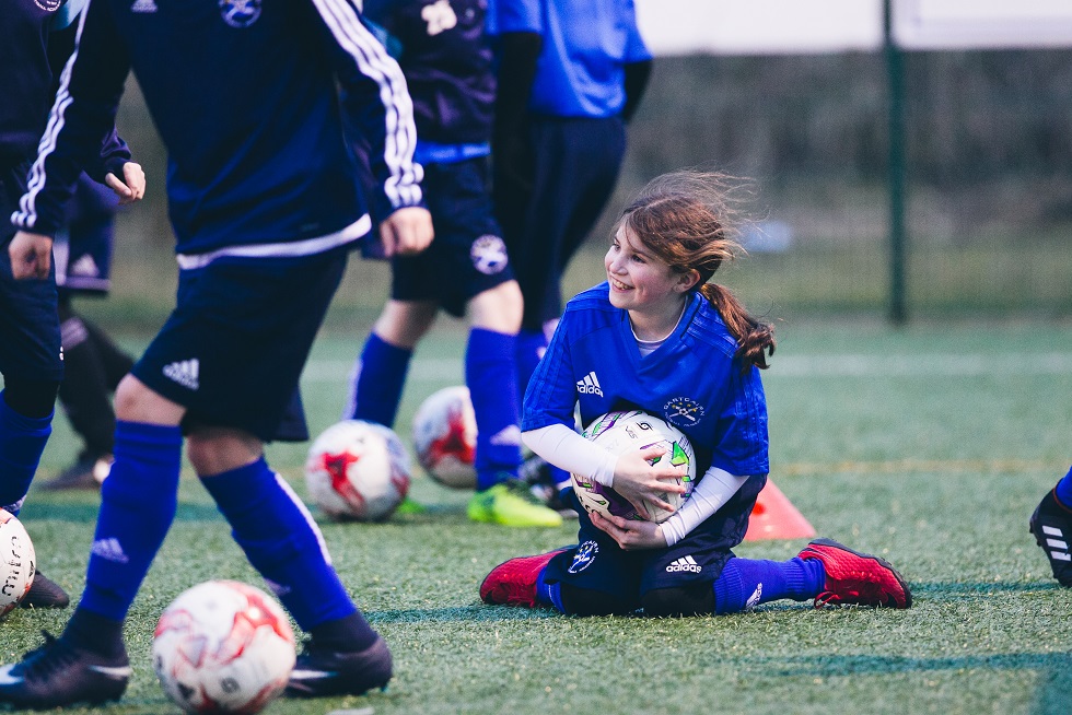 A young player having a ball at training