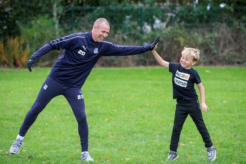 Kenny Miller high fives a young player