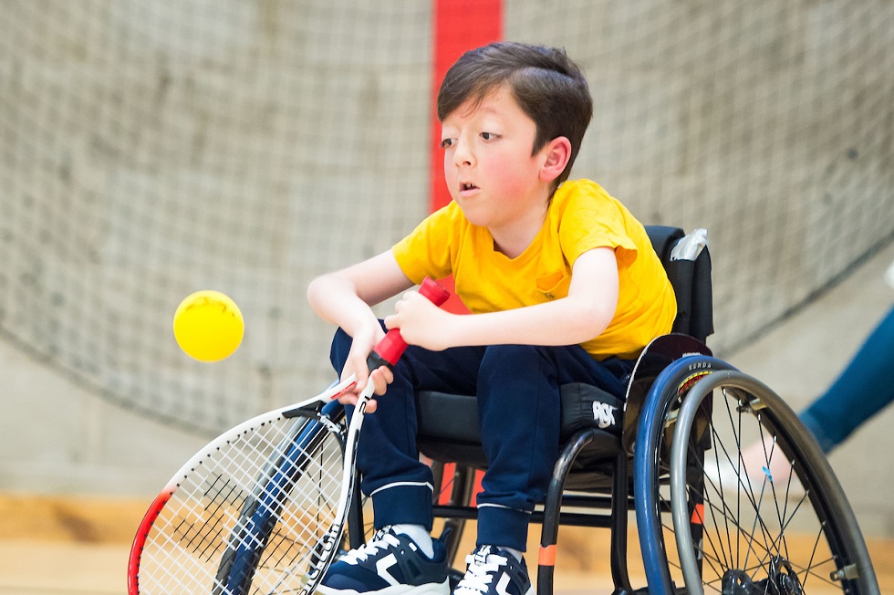 A young male wheelchair tennis participant